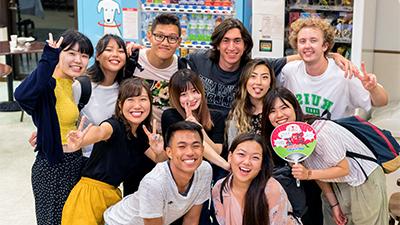 学生 gather with locals in a Japanese store.